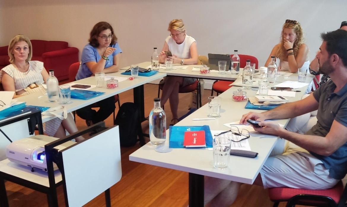 Fotografija prikazuje skupinu učitelja koji razgovaraju.