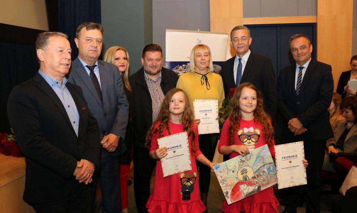 Likovni natječaj „Volim Podravinu i Prigorje”, nagrađen likovni rad učenica Zane i Ene Čičin–Mašansker iz OŠ „Braća Radić” Koprivnica, mentorica i učiteljica Vesna Mlinarić